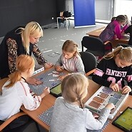 Trenerka pomaga dzieciom kodować
