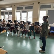 Older students sitting in a circle, listening to the workshop expert.