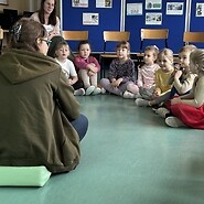 Expert sitting with a group of younger students during a disability awareness ...