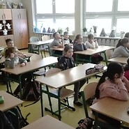 Dzieci siedzą w klasie na zajęciach Klikam z głową