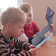 Chłopcy czytają ulotkę