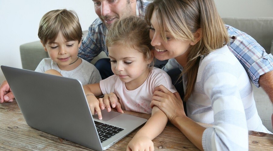 rodzice z dziećmi przed laptopem