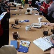 Uczestnicy czytają ulotki UKE przy stole