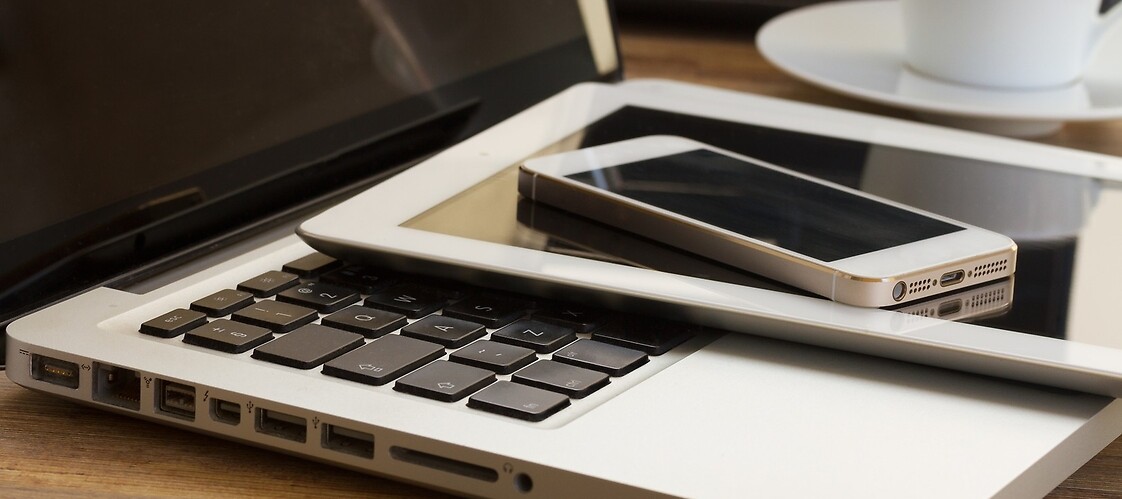 smartfon położony na tablecie a ten położony na laptopie
