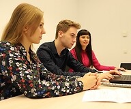 Troje ekspertów UKE prowadzi webinar, siedząc przed komputerem.
