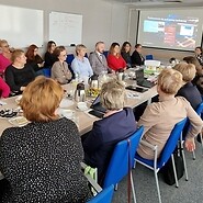 ludzie przy dużym stole konferencyjnym