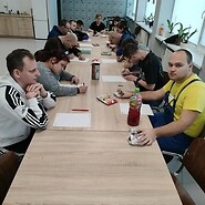 Grupa osób pracuje przy stole.