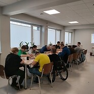Grupa osób przy stole w sali z prezentacją.