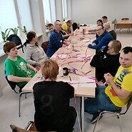 Grupa osób przy stole z różową siatką ze sznurka.