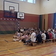uczniowie w sali sportowej słuchają wykładu