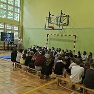 uczniowie w sali sportowej słuchają wykładu