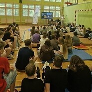 uczniowie w sali sportowej słuchają wykładu