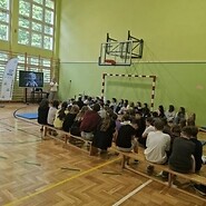 uczniowie w sali sportowej słuchają wykładu