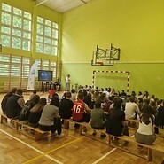 uczniowie w sali sportowej słuchają wykładu