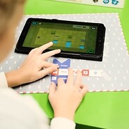 chłopiec układa puzzle na tablecie