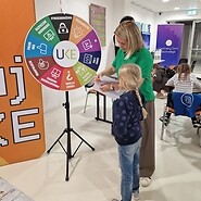 dziewczynka i kobieta stoją przed kołem fortuny