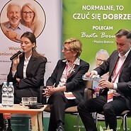 dwóch mężczyzn i jedna kobieta. Kobieta mówi do mikrofonu