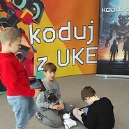trzech chłopców na tle ścianki &quot;koduj z UKE&quot;