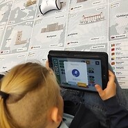 dziecko trzyma w ręku tablet i koduje