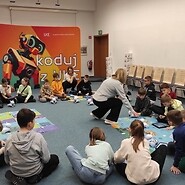 dzieci siedzą na podłodze i kodują