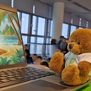 pluszowy miś UKE siedzy przy komputerze