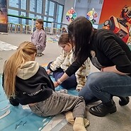 dzieci siedzą na podłodze i kodują