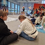 dzieci siedzą na podłodze i kodują