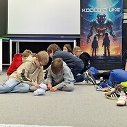 dzieci siedzą na podłodze i kodują