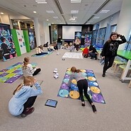 dzieci siedzą na podłodze i kodują