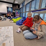 dzieci siedzą na podłodze i kodują