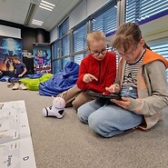 dzieci siedzą na podłodze i kodują