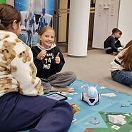 dzieci siedzą na podłodze i kodują