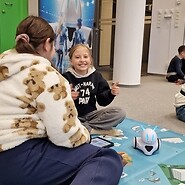 dzieci siedzą na podłodze i kodują