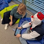 chłopiec siedzi na podłodze i koduje obok chłopca siedzi kobieta