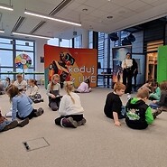 dzieci siedzą na podłodze i kodują