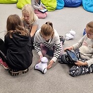 dzieci siedzą na podłodze i kodują