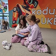 dzieci siedzą na podłodze i kodują