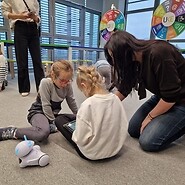 dzieci siedzą na podłodze i kodują