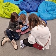 dzieci siedzą na podłodze i kodują