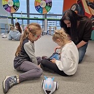 dzieci siedzą na podłodze i kodują