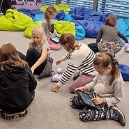 dzieci siedzą na podłodze i kodują