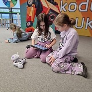 dzieci siedzą na podłodze i kodują