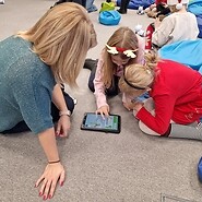 dzieci siedzą na podłodze i kodują