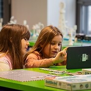 dwie dziewczynki kodują na tablecie