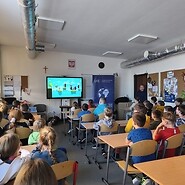 dzieci w sali lekcyjnej słuchają wykładu