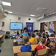 dzieci w sali lekcyjnej słuchają wykładu