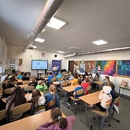 dzieci w sali lekcyjnej słuchają wykładu