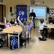 dzieci siedza przy ławkach w sali lecyjnej