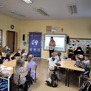 dzieci siedza przy ławkach w sali lecyjnej