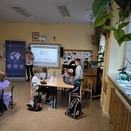 dzieci siedza przy ławkach w sali lecyjnej